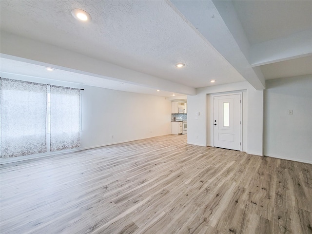 5703 Fraser Ave, Galveston, TX 77551 - interior space with baseboards, recessed lighting, a textured ceiling, and light wood-style flooring