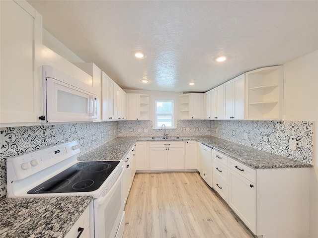 5703 Fraser Ave, Galveston, TX 77551 - kitchen with open shelves, light wood-type flooring, a sink, dark stone counters, and white appliances