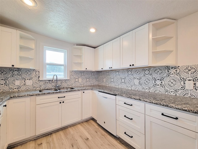 5703 Fraser Ave, Galveston, TX 77551 - kitchen featuring open shelves, stone countertops, light wood-type flooring, a sink, and dishwasher