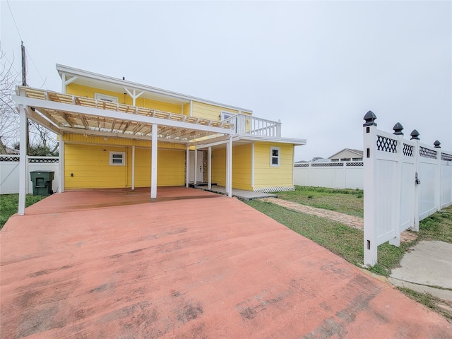 5703 Fraser Ave, Galveston, TX 77551 - exterior space featuring fence, a wooden deck, driveway, and a carport