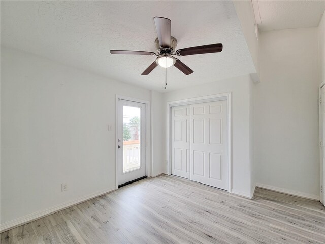 5703 Fraser Ave, Galveston, TX 77551 - unfurnished bedroom with a closet, a textured ceiling, baseboards, and light wood-type flooring