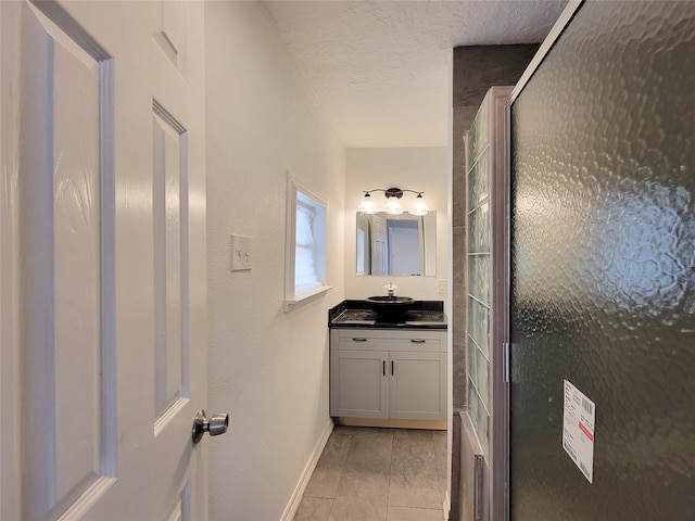5703 Fraser Ave, Galveston, TX 77551 - bathroom featuring vanity, baseboards, a stall shower, and a textured ceiling
