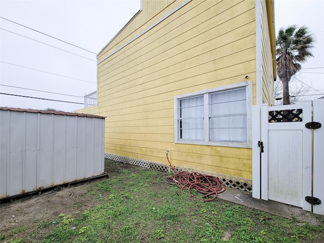 5703 Fraser Ave, Galveston, TX 77551 - view of side of home featuring an outdoor structure, a gate, and a shed