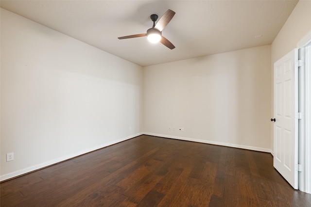 spare room with baseboards, ceiling fan, and dark wood finished floors