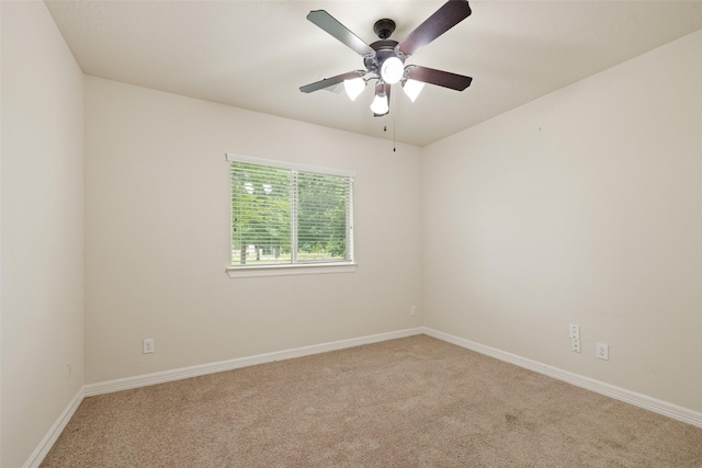 carpeted empty room with baseboards and a ceiling fan