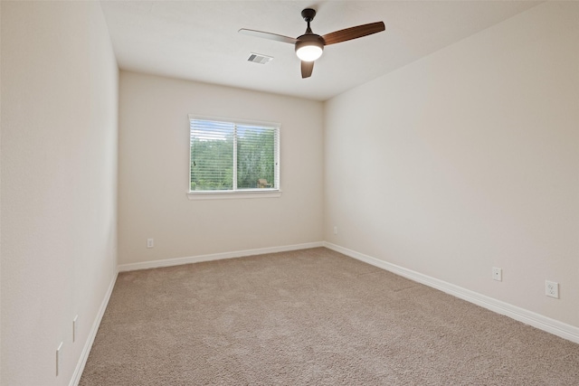 spare room with carpet floors, a ceiling fan, baseboards, and visible vents