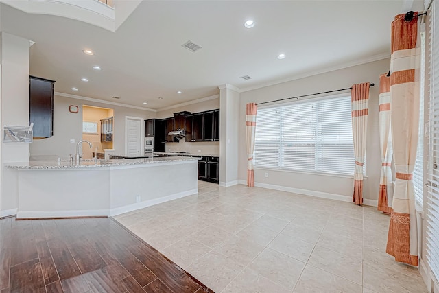 kitchen featuring recessed lighting, baseboards, ornamental molding, and a sink