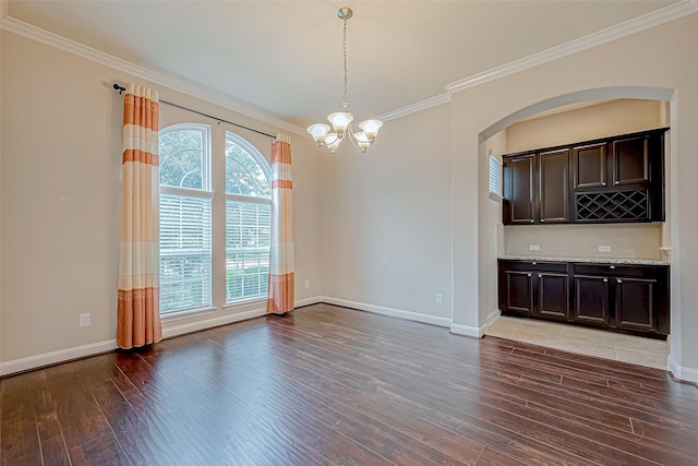interior space with an inviting chandelier, baseboards, ornamental molding, and light wood-type flooring