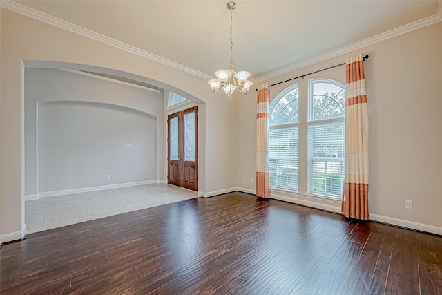 empty room with an inviting chandelier, baseboards, hardwood / wood-style flooring, french doors, and arched walkways