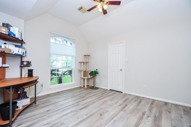 interior space featuring ceiling fan, visible vents, wood finished floors, baseboards, and lofted ceiling