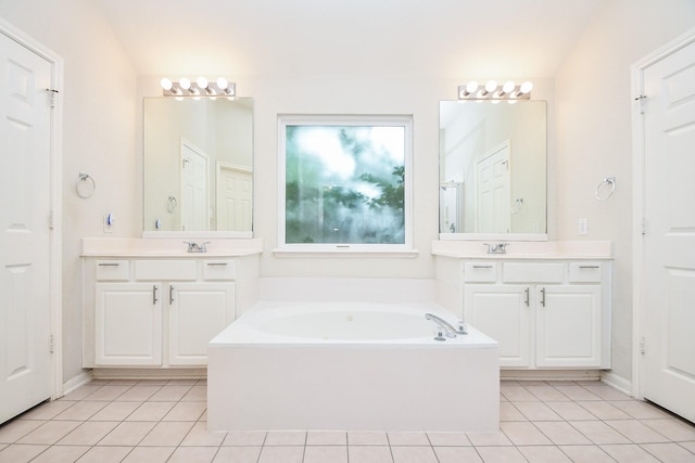 bathroom featuring a sink, tile patterned floors, and a garden tub