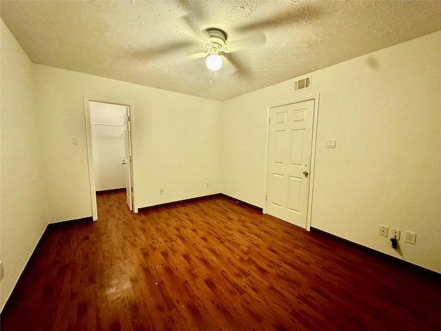 13322 Nantucket Dr, Sugar Land, TX 77478 - unfurnished bedroom featuring dark wood-style flooring, a textured ceiling, visible vents, baseboards, and a spacious closet