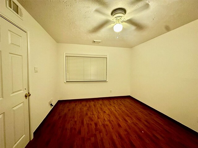 13322 Nantucket Dr, Sugar Land, TX 77478 - spare room featuring visible vents, a textured ceiling, ceiling fan, and dark wood-style floors