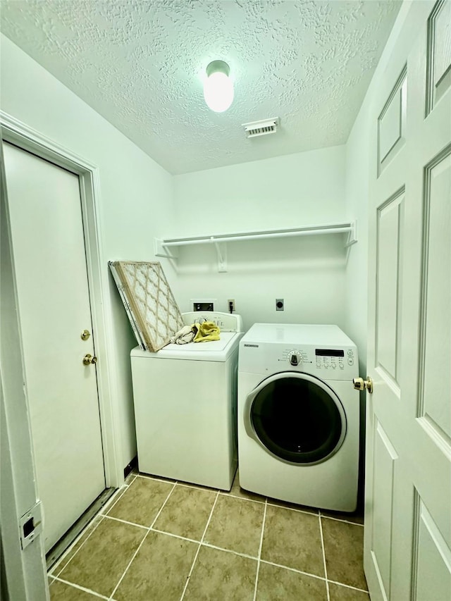 13322 Nantucket Dr, Sugar Land, TX 77478 - washroom featuring laundry area, tile patterned flooring, visible vents, washer and clothes dryer, and a textured ceiling