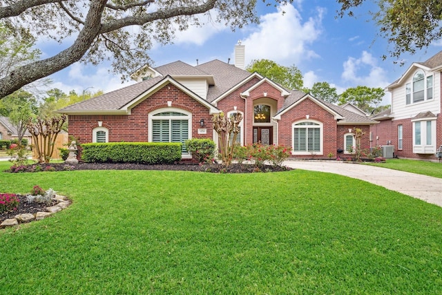 14718 Kings Head Dr, Houston, TX 77044 - ranch-style house with brick siding, a front lawn, central AC, and a chimney
