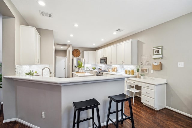 14718 Kings Head Dr, Houston, TX 77044 - kitchen featuring visible vents, a peninsula, appliances with stainless steel finishes, and backsplash