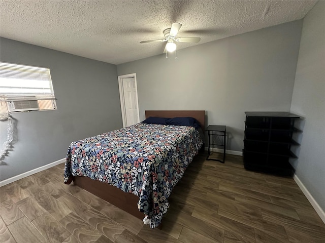 bedroom featuring a ceiling fan, a textured ceiling, wood finished floors, baseboards, and cooling unit