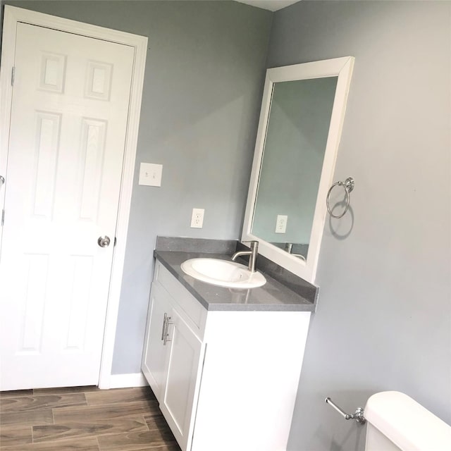 bathroom featuring vanity, wood finished floors, and toilet