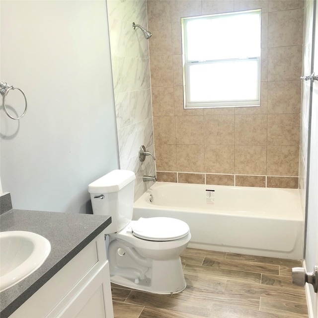 full bathroom with washtub / shower combination, vanity, toilet, and wood finished floors