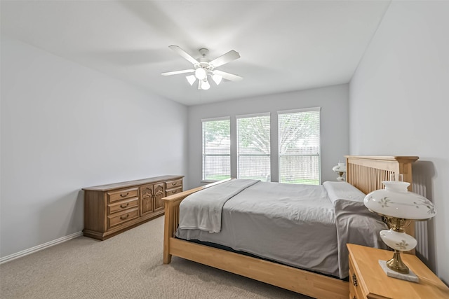 bedroom featuring light colored carpet, baseboards, and ceiling fan