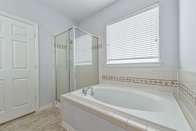 full bathroom with a shower stall and a bath