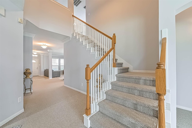 stairway with baseboards, visible vents, and carpet