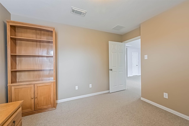 interior space featuring baseboards, light carpet, and visible vents