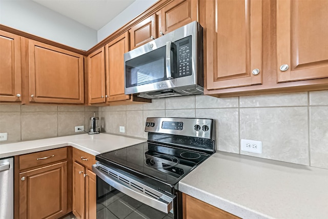 kitchen with light countertops, brown cabinetry, and stainless steel appliances