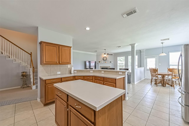 kitchen with freestanding refrigerator, light tile patterned flooring, a fireplace, ceiling fan, and light countertops