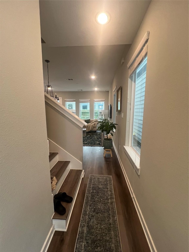 corridor with stairs, recessed lighting, baseboards, and wood finished floors
