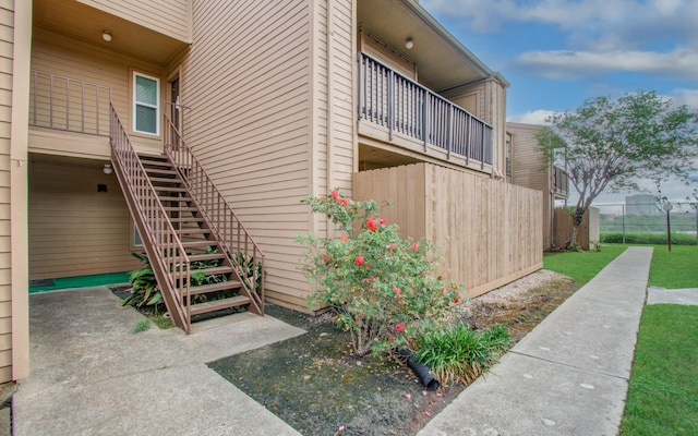 view of home's exterior featuring fence and stairs