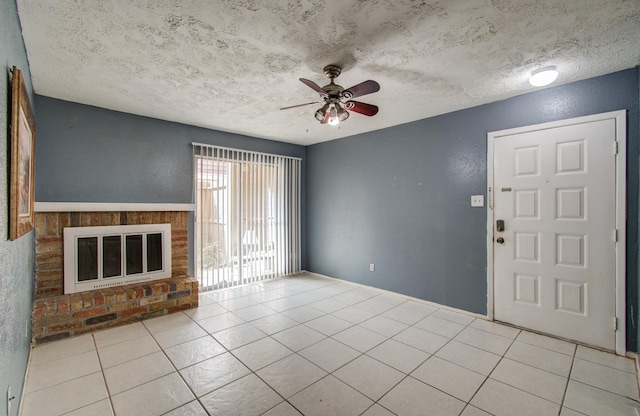 unfurnished living room with a ceiling fan, a textured ceiling, and tile patterned flooring