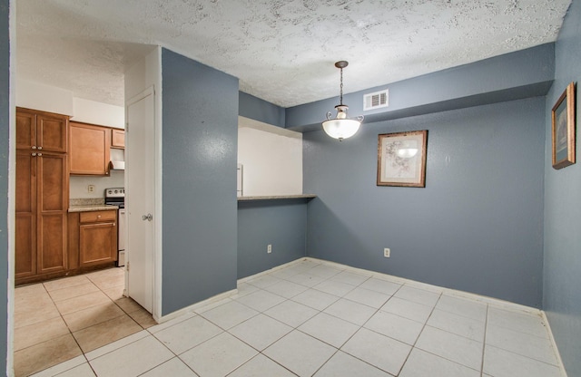 interior space featuring baseboards, a textured ceiling, visible vents, and light tile patterned floors