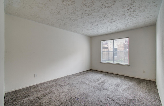 carpeted empty room featuring a textured ceiling