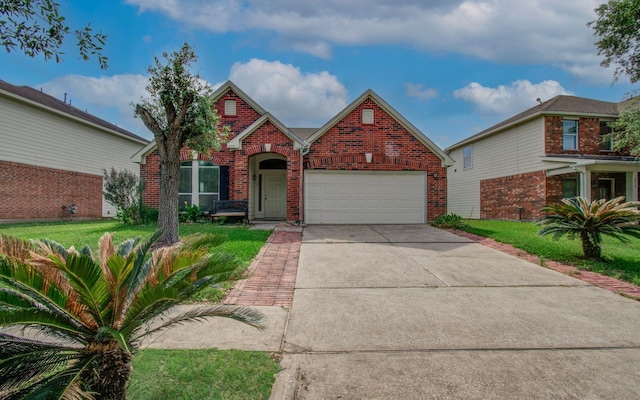 traditional-style home featuring concrete driveway, brick siding, a front yard, and a garage
