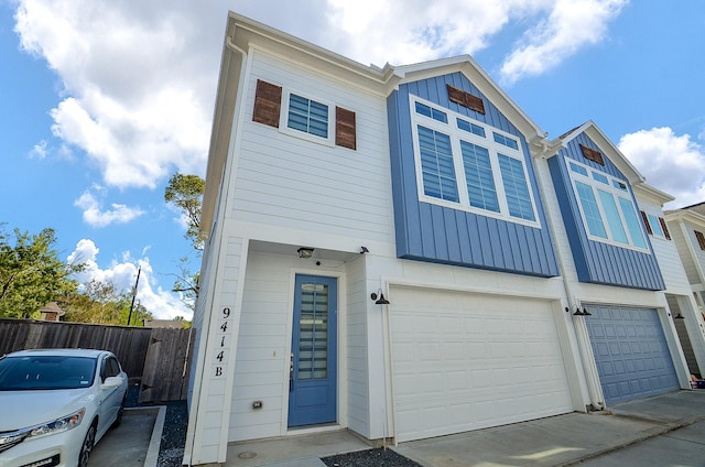 townhome / multi-family property featuring board and batten siding, an attached garage, fence, and driveway