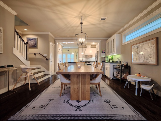 228 E Woodland St, Houston, TX 77009 - dining area featuring baseboards, visible vents, stairs, crown molding, and dark wood-type flooring