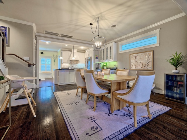228 E Woodland St, Houston, TX 77009 - dining space with a notable chandelier, crown molding, baseboards, wine cooler, and dark wood-style floors