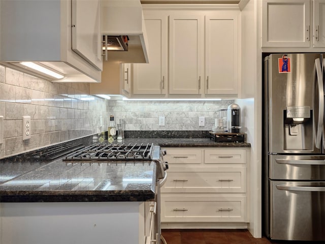 228 E Woodland St, Houston, TX 77009 - kitchen with dark tile patterned floors, white cabinetry, dark countertops, stainless steel appliances, and tasteful backsplash