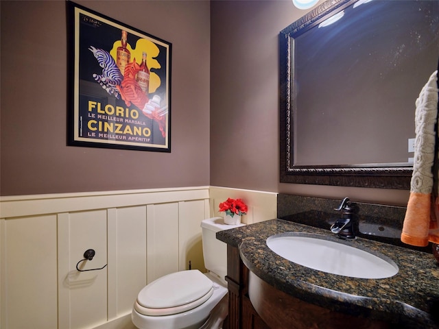 228 E Woodland St, Houston, TX 77009 - bathroom featuring vanity, toilet, and a wainscoted wall