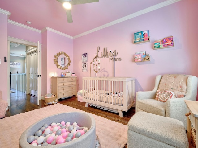 228 E Woodland St, Houston, TX 77009 - bedroom featuring baseboards, a nursery area, ceiling fan, crown molding, and wood finished floors