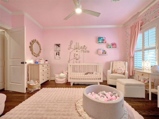 228 E Woodland St, Houston, TX 77009 - bedroom featuring crown molding, a ceiling fan, a crib, and dark wood finished floors