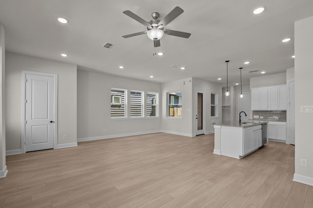 unfurnished living room with a ceiling fan, baseboards, recessed lighting, light wood-type flooring, and visible vents