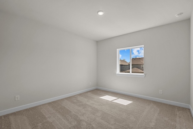 carpeted empty room featuring baseboards