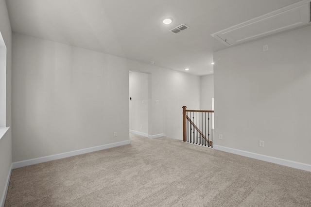 carpeted spare room featuring visible vents, attic access, baseboards, and recessed lighting