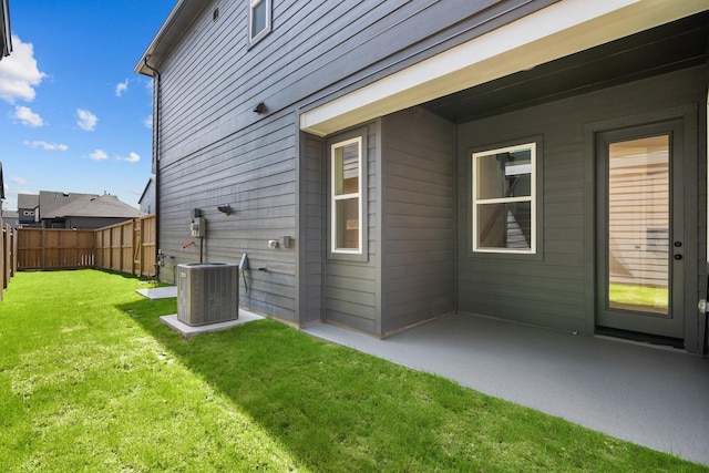 back of property featuring a patio, central AC unit, a fenced backyard, and a yard