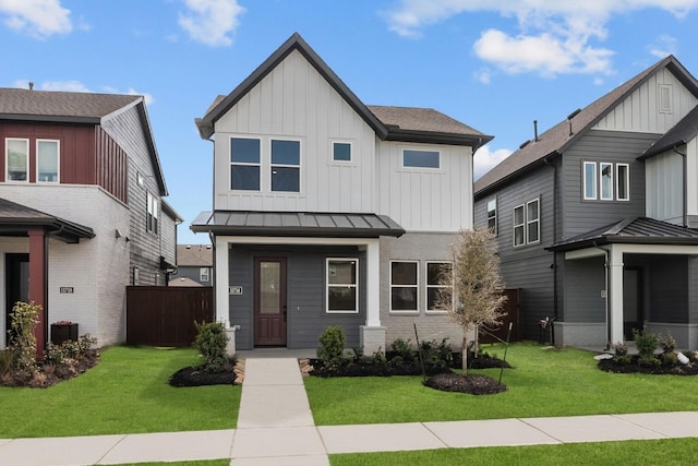 view of front of home with fence, a front yard, a standing seam roof, board and batten siding, and metal roof