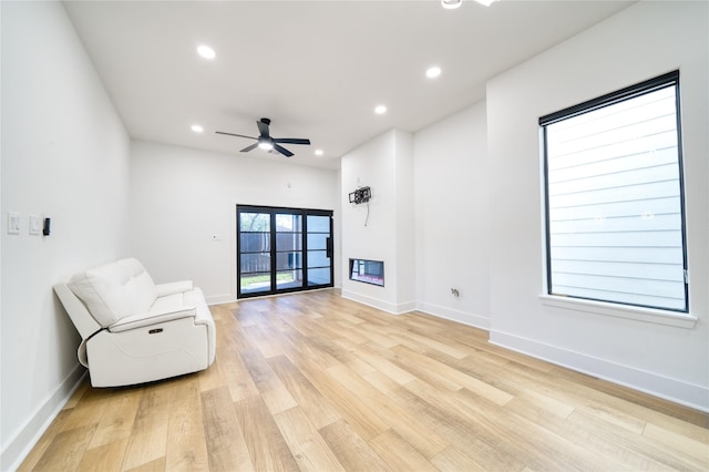 2420 Sumpter St, Houston, TX 77026 - unfurnished room featuring a glass covered fireplace, light wood-style floors, baseboards, ceiling fan, and recessed lighting