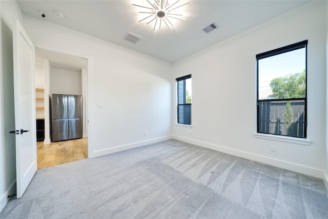 2420 Sumpter St, Houston, TX 77026 - spare room with baseboards, light carpet, and visible vents
