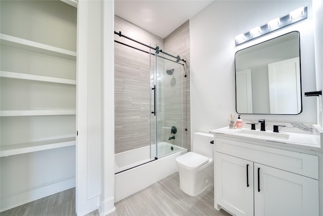 2420 Sumpter St, Houston, TX 77026 - full bathroom featuring vanity, combined bath / shower with glass door, wood finished floors, and toilet
